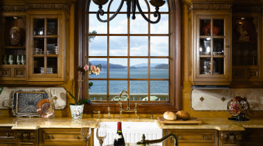 A view of this elegant kitchen featuring gold cabinetry, ceiling, countertop, estate, home, interior design, kitchen, lighting, room, window, brown