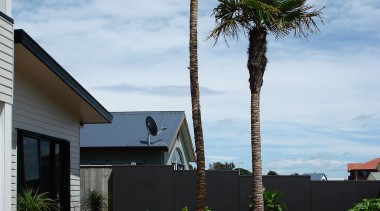 View of this outdoor enertainment area featuring landscaped agave, arecales, home, house, landscaping, outdoor structure, palm tree, plant, real estate, sky, tree, walkway, woody plant, white