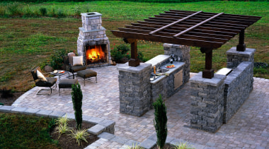 Outdoor entertainment and barbeque patio area with paved landscape, outdoor structure, green