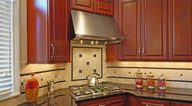 View of this kitchen designed and manufactured by cabinetry, countertop, cuisine classique, flooring, hardwood, home, interior design, kitchen, room, under cabinet lighting, wood stain, brown, red