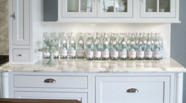 A view of this white kitchen featuring traditional bathroom accessory, bathroom cabinet, cabinetry, chest of drawers, countertop, cuisine classique, drawer, floor, flooring, furniture, hardwood, home, interior design, kitchen, room, sink, window, wood stain, gray, white