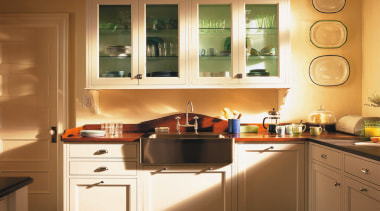 A view of this kitchen featuring traditional colonial cabinetry, countertop, cuisine classique, floor, flooring, furniture, hardwood, interior design, kitchen, room, under cabinet lighting, window, wood flooring, brown