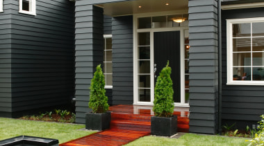 A view of a home designed and built backyard, cottage, facade, home, house, lawn, porch, property, real estate, residential area, shed, siding, window, yard, black