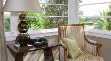 A view of this upholstered chair, glass lampstand chair, furniture, home, house, interior design, living room, porch, room, table, window, window covering, window treatment, gray