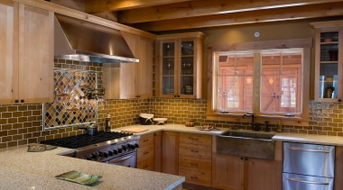 A view of this kitchen featuring stainless steel cabinetry, countertop, cuisine classique, flooring, interior design, kitchen, real estate, under cabinet lighting, brown