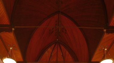 A view of this protected heritage church at arch, architecture, ceiling, chandelier, chapel, light, light fixture, lighting, lighting accessory, symmetry, wood, red, brown