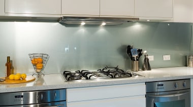 A view of this kitchen featuring tiled flooring, countertop, glass, interior design, kitchen, major appliance, room, under cabinet lighting, gray