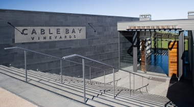 The entrance brings patrons downstairs into a foyer architecture, building, structure, gray