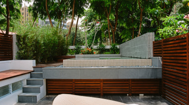 A view of this outdoor entertainment area featuring backyard, courtyard, estate, furniture, house, landscaping, outdoor furniture, outdoor structure, patio, plant, property, real estate, table, walkway, wall, yard