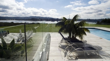 A view of this outdoor pool area featuring leisure, outdoor structure, property, real estate, sky, swimming pool, water, white