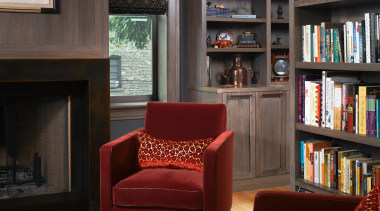 A view of this living area featuring red bookcase, floor, flooring, furniture, home, interior design, library, living room, shelf, shelving, black, gray