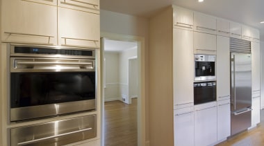 A view of this minimalist clean lined kitchen cabinetry, countertop, home appliance, kitchen, kitchen appliance, kitchen stove, major appliance, microwave oven, oven, refrigerator, room, gray, brown