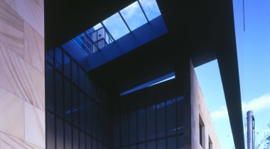 A deep overhead canopy covers the entrance to architecture, building, commercial building, corporate headquarters, daylighting, daytime, facade, glass, headquarters, house, mixed use, sky, structure, black, blue