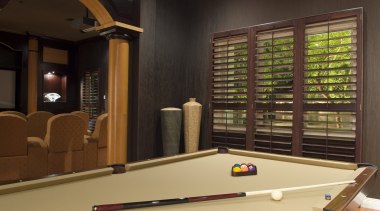 A view of the interior living areas featuring billiard room, billiard table, english billiards, games, indoor games and sports, interior design, pool, recreation room, room, table, wood, brown, black