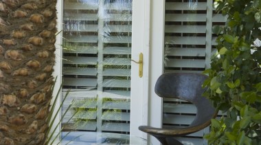 A view of the outdoor furniture and sculptures door, home, house, outdoor structure, plant, tree, window, wood, brown, gray