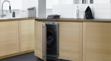 A view of this clean, contemporary laundry featuring cabinetry, clothes dryer, countertop, floor, furniture, home appliance, kitchen, kitchen appliance, kitchen stove, major appliance, product, product design, refrigerator, washing machine, white