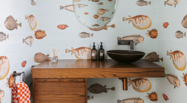 The powder room upstairs features fish wallpaper and 