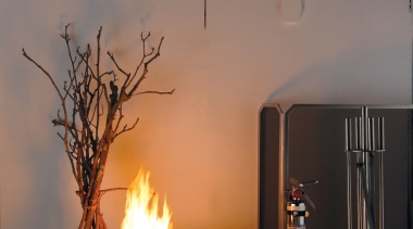 A view of a fireplace from Real Fires. ceiling, fireplace, hearth, heat, home, interior design, lamp, light fixture, lighting, lighting accessory, still life photography, table, wood, gray, black