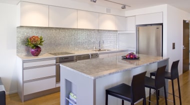 View of kitchen featuring wall tiling, kitchen island, cabinetry, countertop, floor, flooring, interior design, kitchen, real estate, room, gray