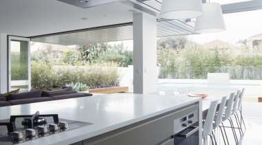 Bifold doors open up the interior to the countertop, interior design, kitchen, gray, white