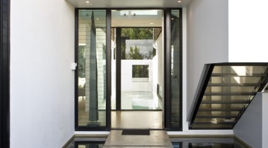 The water feature at the front entrance creates architecture, condominium, daylighting, estate, home, house, interior design, property, real estate, window, white, black