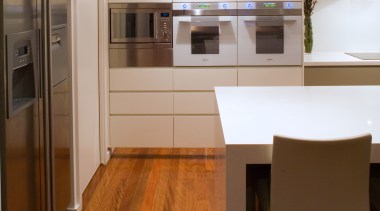 The side-by-side fridge/freezer has a dispenser for chilled cabinetry, countertop, floor, flooring, hardwood, interior design, kitchen, laminate flooring, lighting, room, wood, wood flooring, brown