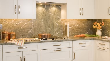 Image of a showroom kitchen at the A&amp;D cabinetry, countertop, cuisine classique, floor, flooring, furniture, home, interior design, kitchen, room, tile, under cabinet lighting, wall, white