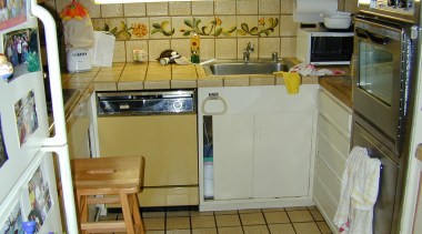 A view of the cramped and awkward original countertop, floor, flooring, kitchen, major appliance, property, room, brown, gray