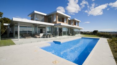 Extending almost the length of the house, the architecture, estate, facade, home, house, mansion, property, real estate, residential area, sky, swimming pool, villa, white