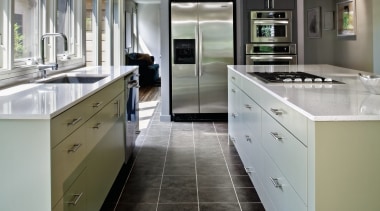 View of a kitchen which features a large cabinetry, countertop, cuisine classique, floor, home appliance, interior design, kitchen, gray