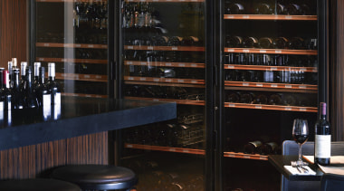 This eatery and wine bar displays a broad furniture, interior design, liquor store, restaurant, wine cellar, black