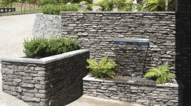 View of garden which includes a stone wall stone wall, walkway, wall, white