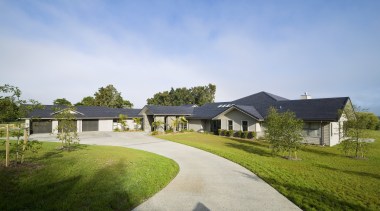 Image of this family home which creates a cloud, cottage, estate, facade, farm, farmhouse, grass, home, house, land lot, landscape, lawn, property, real estate, residential area, sky, suburb, tree, villa, teal