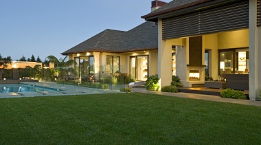 View of contemporary home with light-toned and beige backyard, estate, facade, hacienda, home, house, landscaping, lawn, leisure, mansion, property, real estate, residential area, resort, swimming pool, villa, window, green