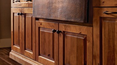 View of a kitchen which features wooden cabinetry cabinetry, chest of drawers, countertop, drawer, floor, flooring, furniture, hardwood, laminate flooring, sideboard, tile, wood, wood flooring, wood stain, brown