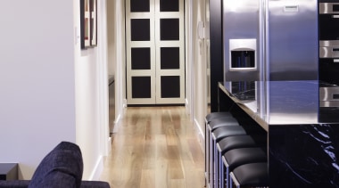View of an apartment kitchen which features solid floor, flooring, hardwood, interior design, laminate flooring, living room, room, wood, wood flooring, white, black