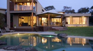 exterior view of a residence which was designed architecture, backyard, cottage, elevation, estate, facade, home, house, landscape lighting, lighting, mansion, property, real estate, reflection, residential area, resort, swimming pool, villa, window, teal