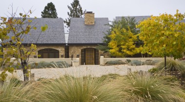 Low stucco walls enclose this new country house, cottage, estate, garden, grass, grass family, home, house, landscape, landscaping, plant, property, real estate, brown