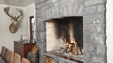 In the dining area of the home this fireplace, hearth, interior design, wood burning stove, gray