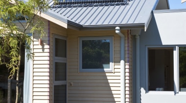 Exterior view of David Reid show home which backyard, cottage, elevation, estate, facade, home, house, outdoor structure, property, real estate, residential area, roof, siding, window, white