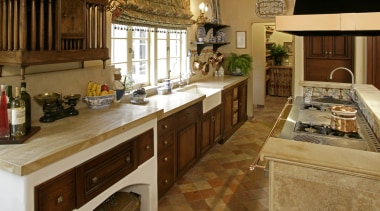 View of French-styled farmhouse kitchen which features terra cabinetry, countertop, cuisine classique, flooring, interior design, kitchen, room, brown