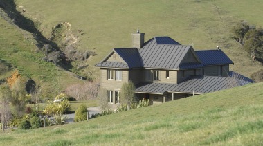Exterior view of a farm house built by cottage, estate, farm, farmhouse, field, grass, grassland, highland, hill, home, house, hut, land lot, landscape, meadow, mountain, pasture, property, real estate, rural area, sky, tree, village, yellow