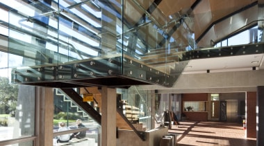 Interior close-up of the large stairway that joins architecture, building, ceiling, daylighting, glass, lobby, structure, brown