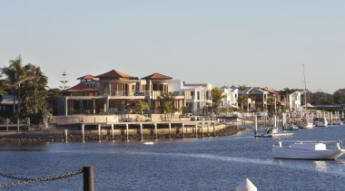 View of the exterior of this contemporary home boat, city, dock, harbor, home, marina, port, real estate, reflection, residential area, resort, sea, sky, tree, water, waterway, gray