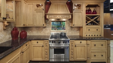View of a traditional styled kitchen which features cabinetry, countertop, cuisine classique, flooring, hardwood, interior design, kitchen, room, under cabinet lighting, wood flooring, brown, orange