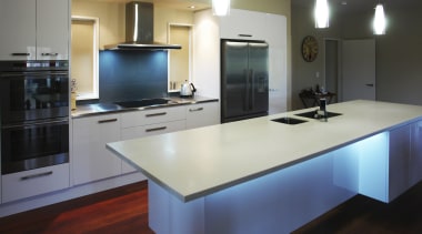 View of a kitchen which features an island cabinetry, countertop, floor, hardwood, interior design, kitchen, real estate, room, gray, black