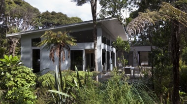 View of contemporary home surrounded by trees. - cottage, estate, home, house, plant, property, real estate, tree, villa, black, brown