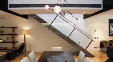 View of dining area in contemporary apartment. - architecture, ceiling, floor, home, interior design, light fixture, lighting, living room, loft, product design, table, wall, gray, black