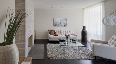 Lounge area with glass table and white couches. architecture, floor, flooring, home, house, interior design, interior designer, living room, real estate, room, table, wall, gray