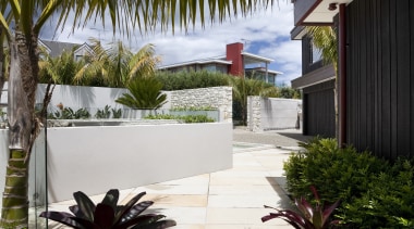 View of landscaping and patio area of contemporary arecales, backyard, cottage, estate, hacienda, home, house, outdoor structure, palm tree, plant, property, real estate, resort, tree, tropics, vacation, villa, walkway, brown